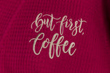 Detail of wine-colored robe featuring "But first, coffee" in latte-colored script text.