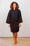 Woman wearing a knee-length black robe.
