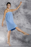 A woman wears a light blue bath wrap.