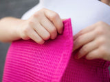 The Velcro strip closing a pink bath wrap is fastened.